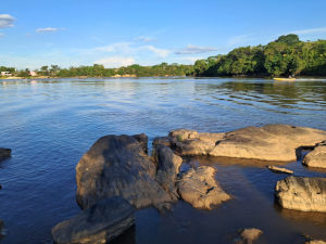 Imagem de um rio poluído com lixo nas margens